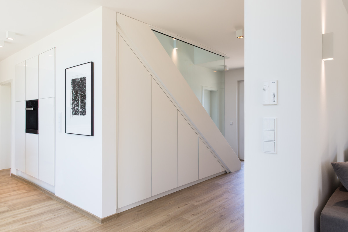 Ejemplo de entrada moderna de tamaño medio con paredes blancas, suelo vinílico y suelo beige