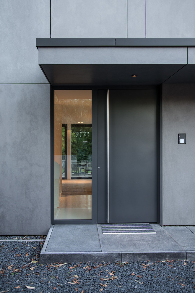 Imagen de puerta principal contemporánea pequeña con paredes grises, suelo de cemento, puerta doble, puerta negra y suelo gris