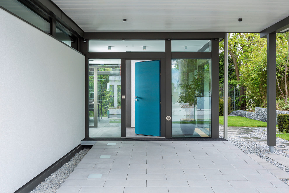 他の地域にある広いコンテンポラリースタイルのおしゃれな玄関 (白い壁、セラミックタイルの床、青いドア、グレーの床) の写真