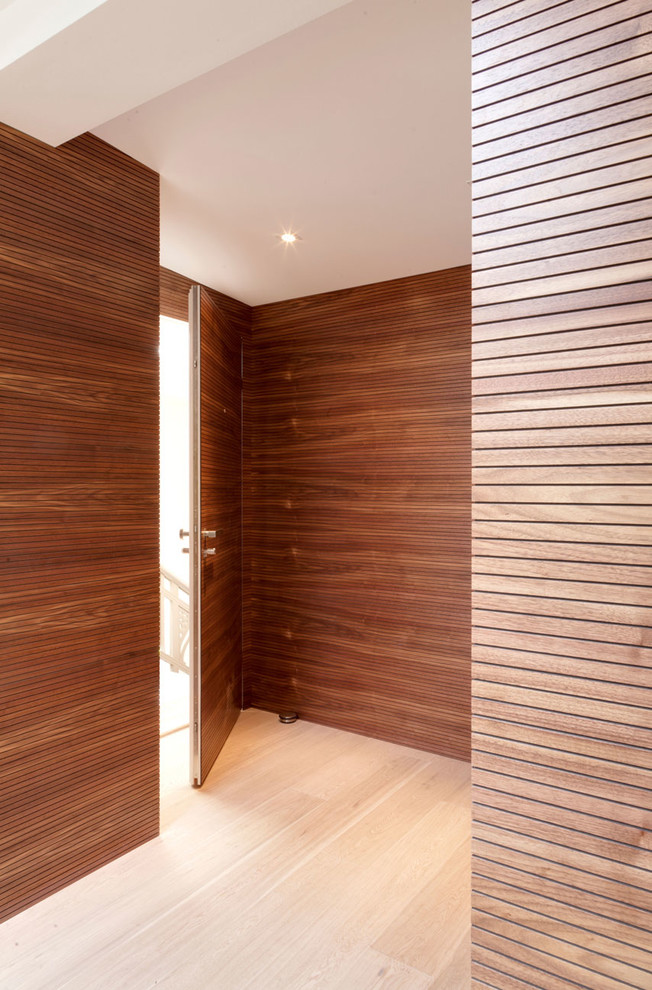 Idee per un corridoio design di medie dimensioni con pareti marroni, una porta singola, pavimento beige, parquet chiaro e una porta in legno bruno
