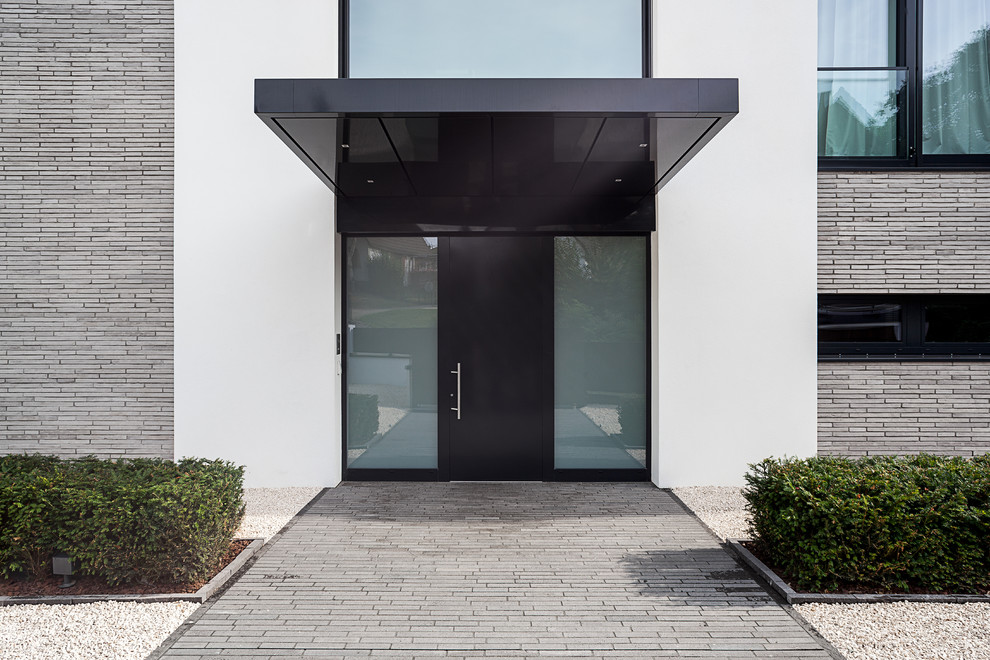 Idées déco pour une porte d'entrée contemporaine avec un mur blanc, une porte simple et une porte noire.