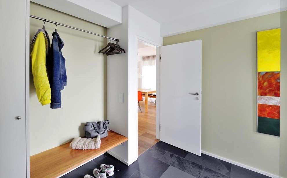 Modelo de distribuidor minimalista de tamaño medio con paredes verdes, suelo de granito, puerta simple, puerta blanca y suelo gris