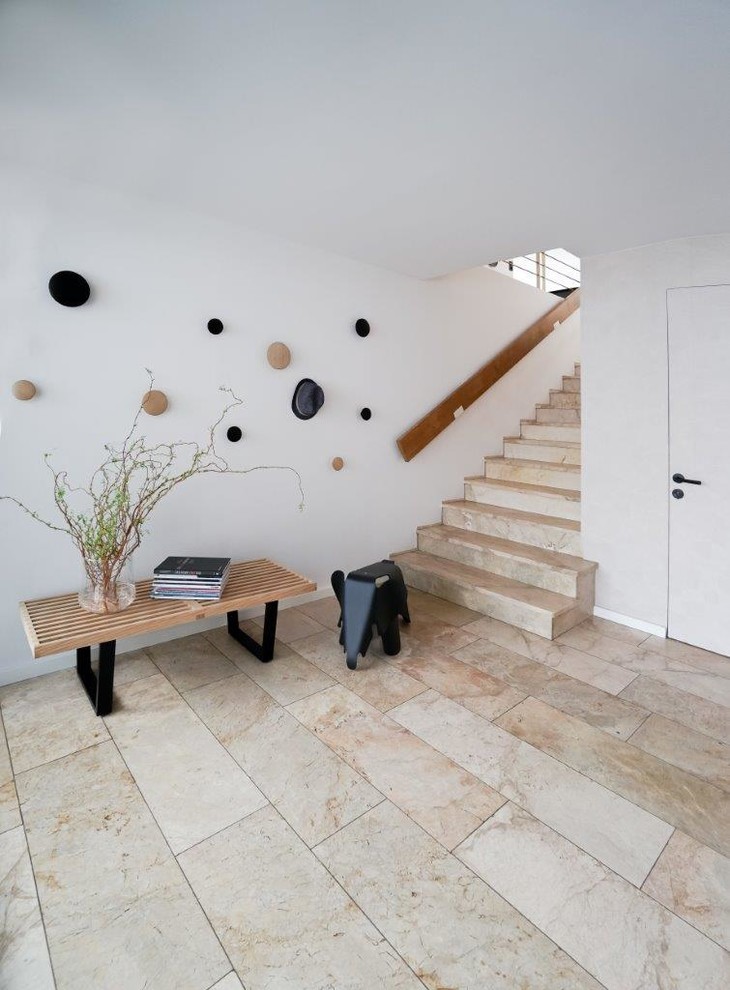 Immagine di un ingresso moderno con pareti bianche, pavimento in marmo, una porta singola, pavimento beige, soffitto in carta da parati e carta da parati
