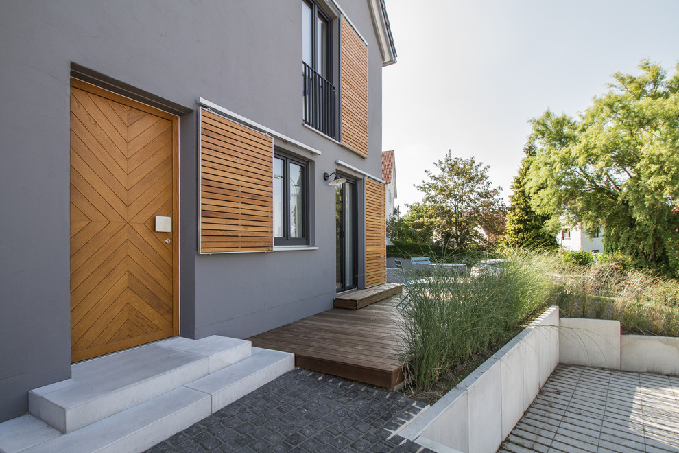 Идея дизайна: входная дверь среднего размера в скандинавском стиле с серыми стенами, одностворчатой входной дверью, входной дверью из дерева среднего тона и серым полом