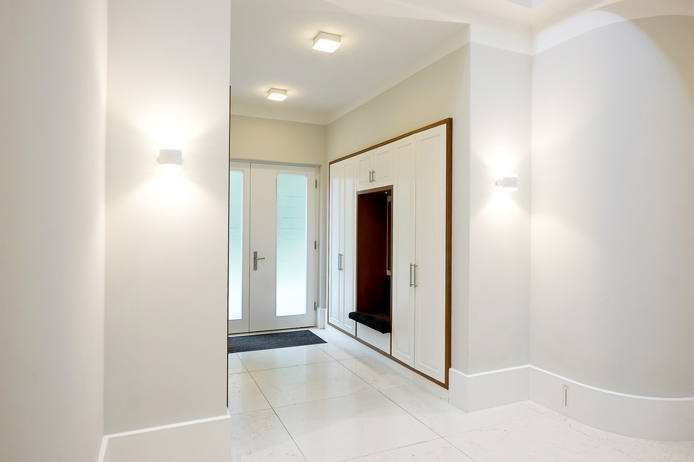 Idée de décoration pour une entrée design de taille moyenne avec un vestiaire, un mur blanc, sol en béton ciré, une porte double, une porte en verre et un sol blanc.