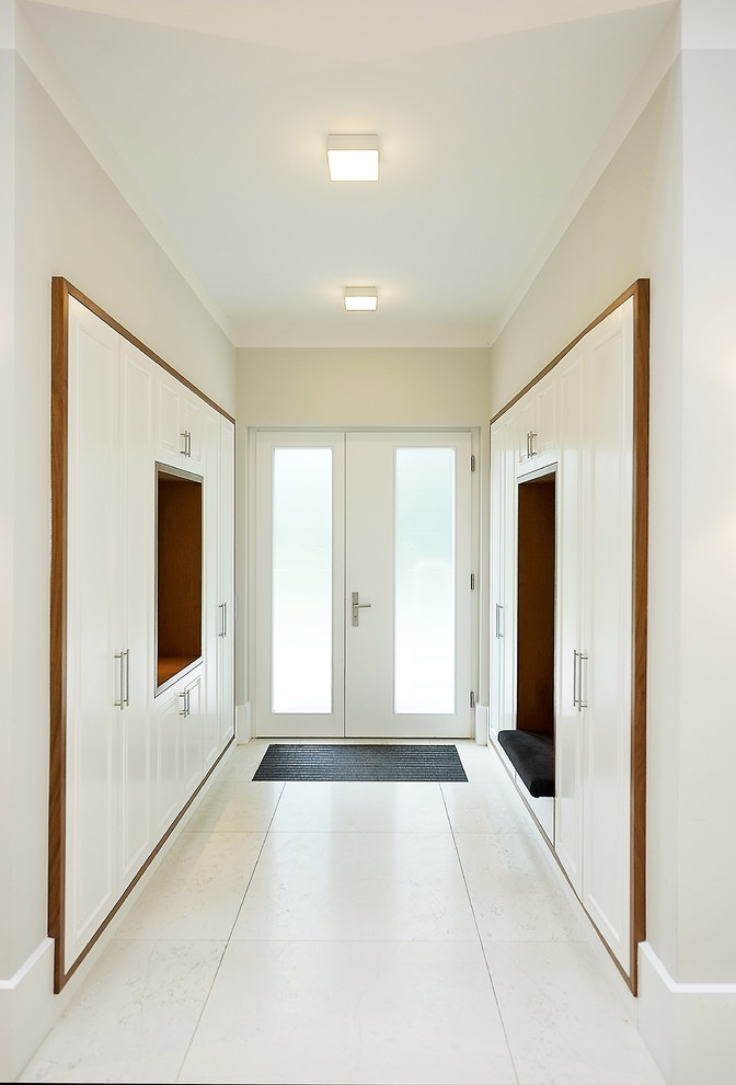 Пример оригинального дизайна: тамбур среднего размера в современном стиле с белыми стенами, двустворчатой входной дверью, стеклянной входной дверью, бетонным полом и белым полом