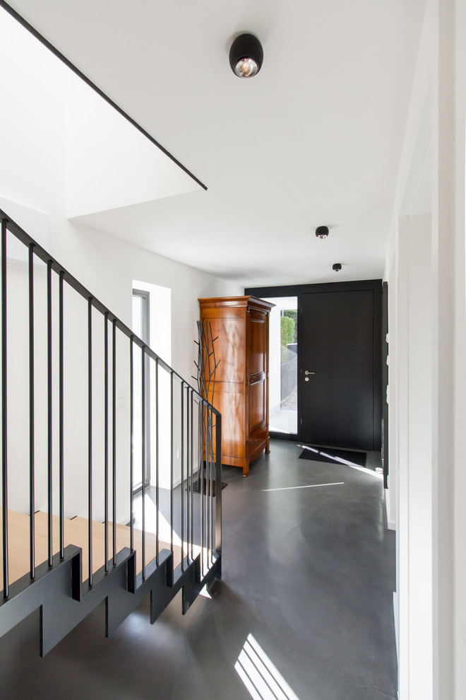 Стильный дизайн: входная дверь среднего размера в современном стиле с белыми стенами, полом из винила, одностворчатой входной дверью, черной входной дверью и серым полом - последний тренд
