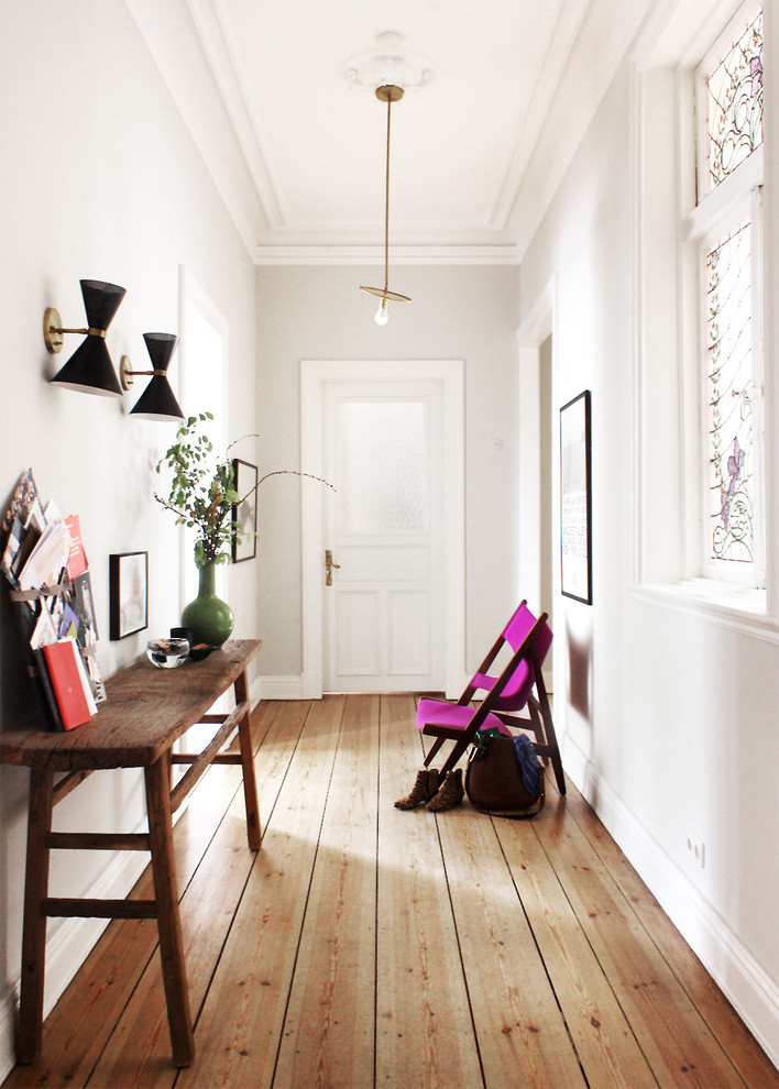Источник вдохновения для домашнего уюта: узкая прихожая среднего размера в скандинавском стиле с паркетным полом среднего тона, одностворчатой входной дверью, белой входной дверью, коричневым полом и белыми стенами