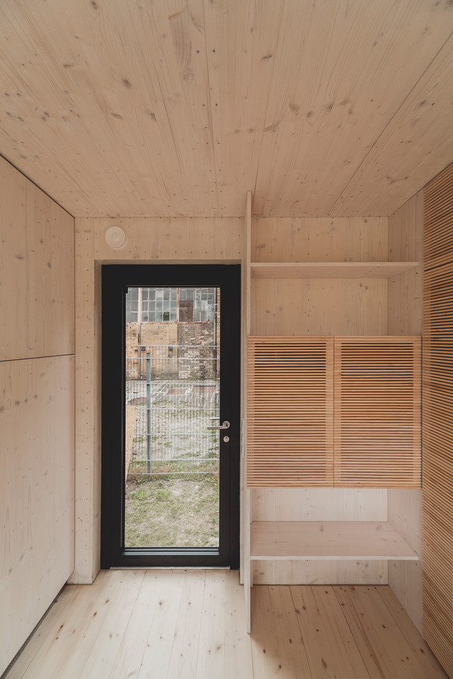 Foto på en liten funkis ingång och ytterdörr, med ljust trägolv och en enkeldörr