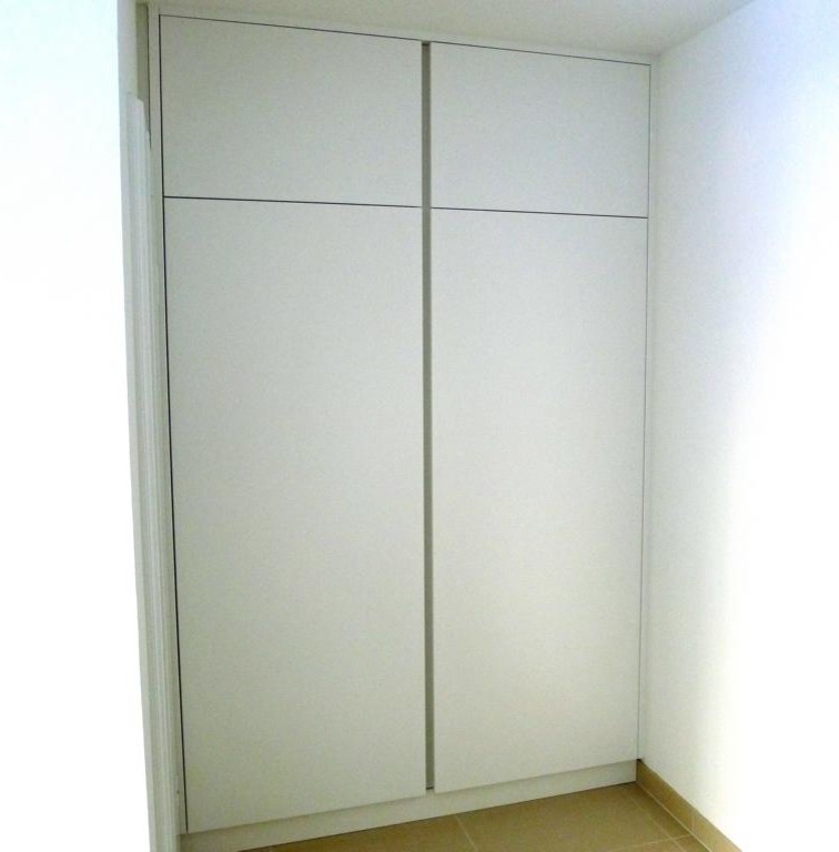 Cette photo montre une entrée tendance avec un mur blanc et un sol beige.
