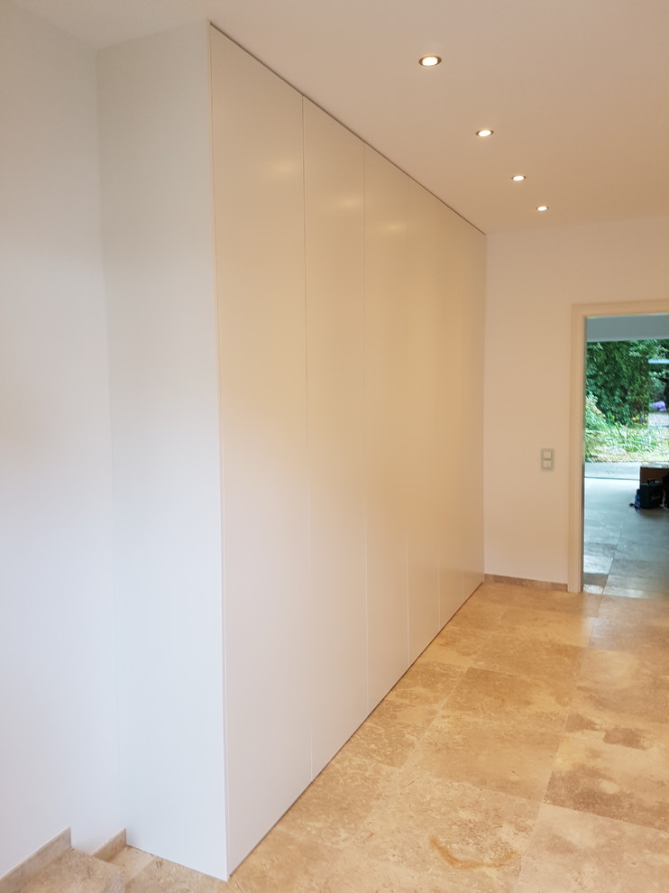 高級な広いコンテンポラリースタイルのおしゃれな玄関ロビー (白い壁、テラゾーの床、ベージュの床) の写真