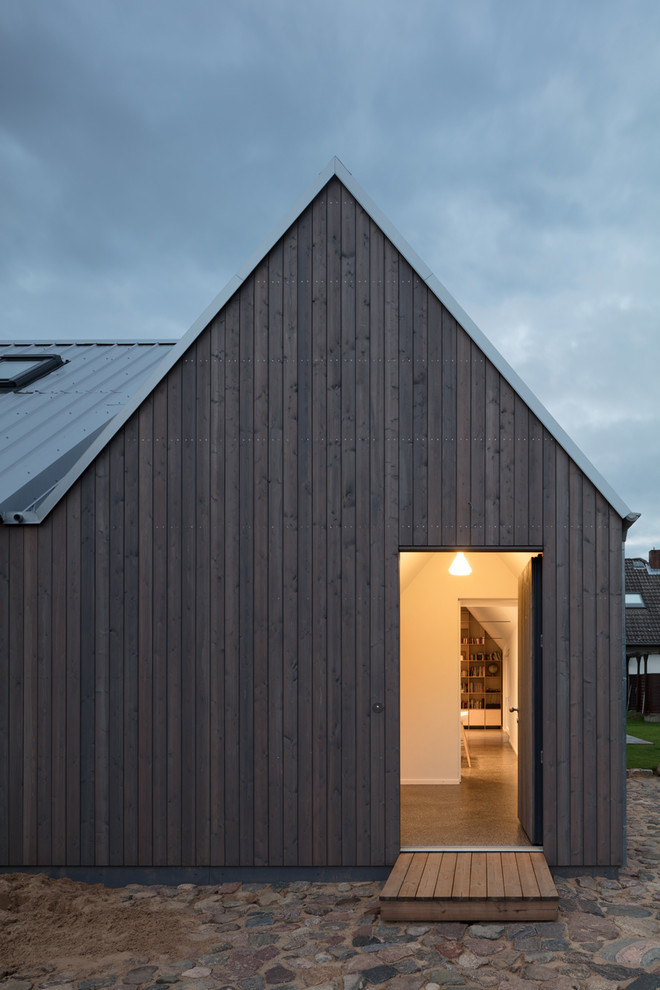 Diseño de puerta principal nórdica pequeña con paredes blancas, puerta simple, puerta marrón, suelo negro y suelo de terrazo