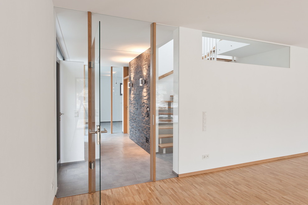 Ejemplo de hall contemporáneo de tamaño medio con paredes blancas, puerta simple y puerta de vidrio