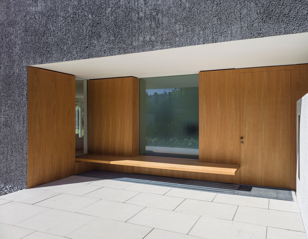 Diseño de puerta principal minimalista con paredes grises, puerta simple y puerta de madera en tonos medios