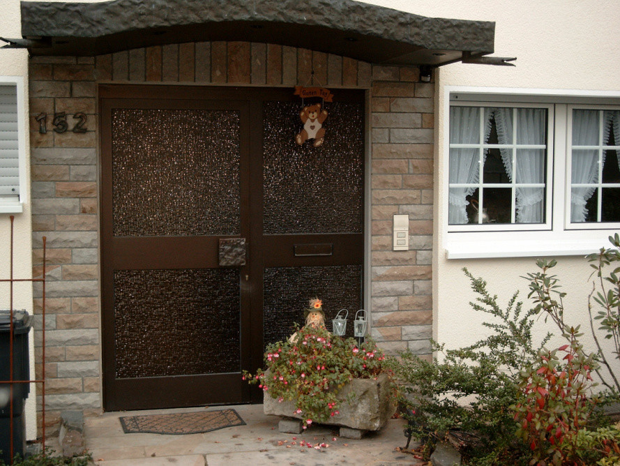 Imagen de puerta principal campestre de tamaño medio con puerta simple y puerta de madera clara