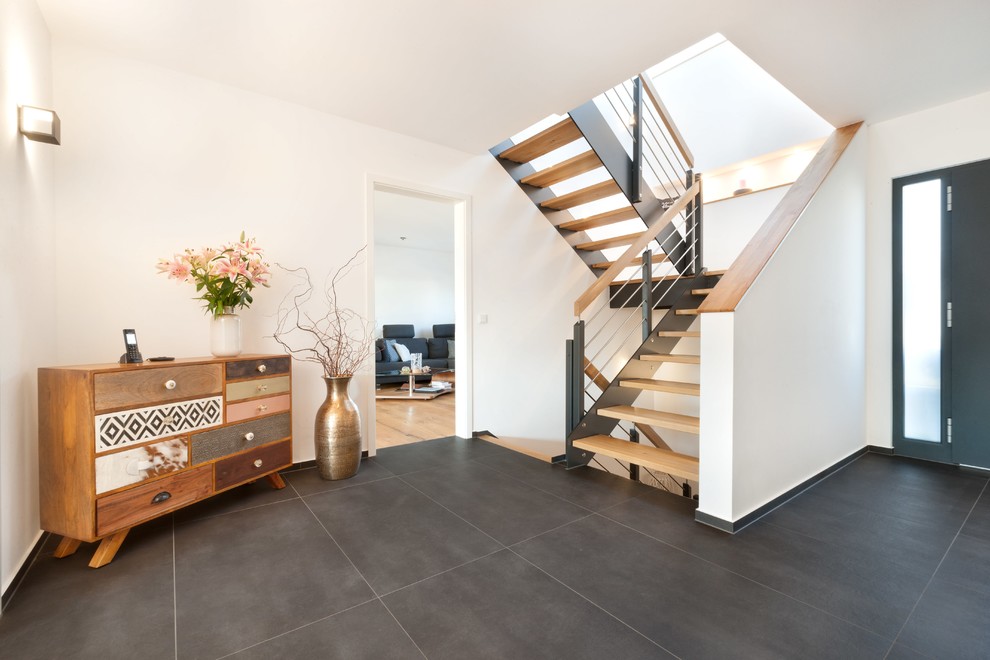 Mittelgroßes Modernes Foyer mit weißer Wandfarbe, Keramikboden, Einzeltür, grauer Haustür und schwarzem Boden in Stuttgart