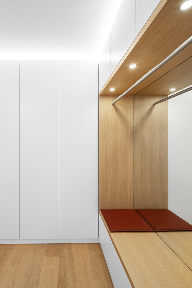 Bild på ett mellanstort funkis kapprum, med vita väggar, mellanmörkt trägolv och brunt golv