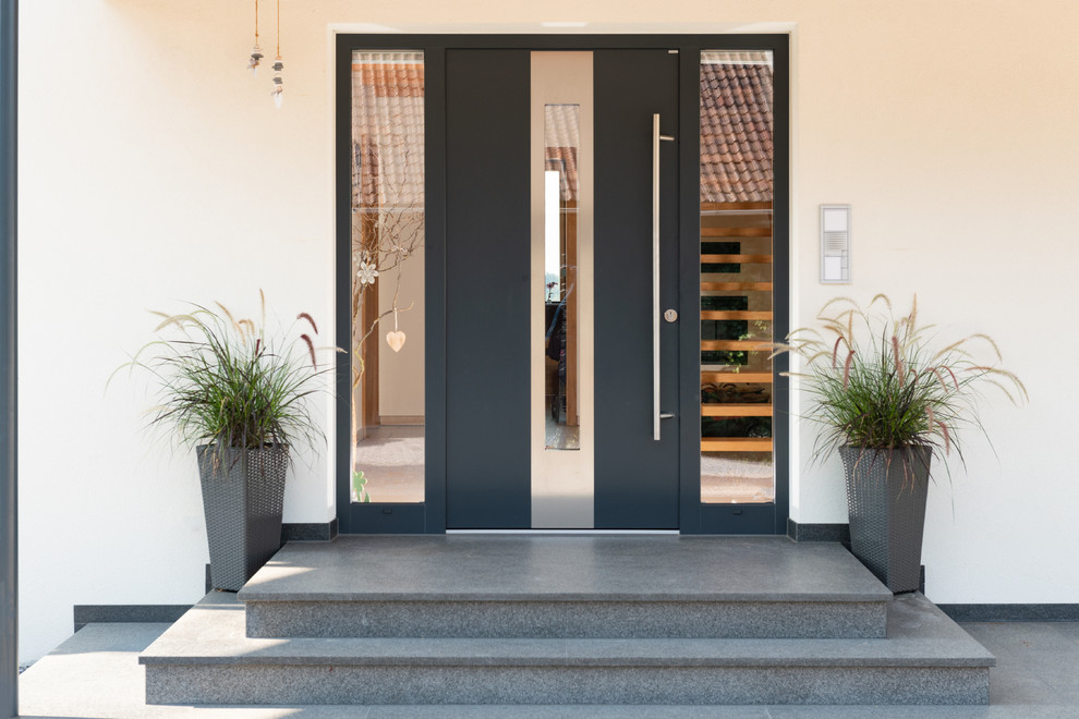 Стильный дизайн: входная дверь среднего размера в современном стиле с белыми стенами, гранитным полом, одностворчатой входной дверью, черной входной дверью и серым полом - последний тренд