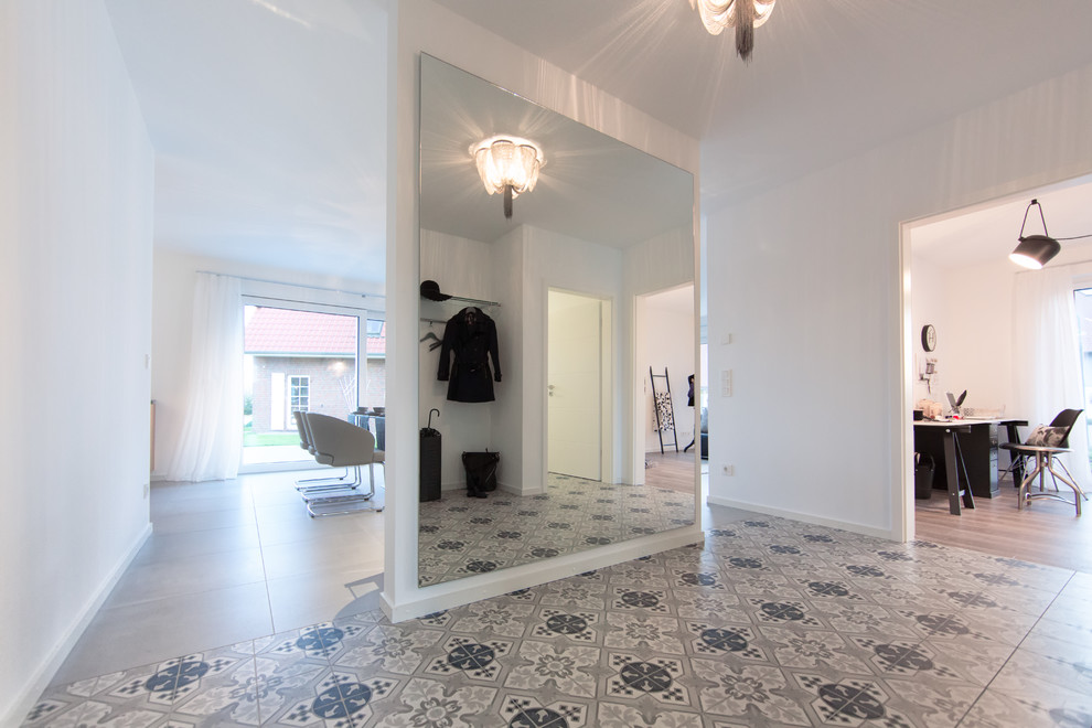 Großes Klassisches Foyer mit weißer Wandfarbe, Porzellan-Bodenfliesen und grauem Boden in Sonstige