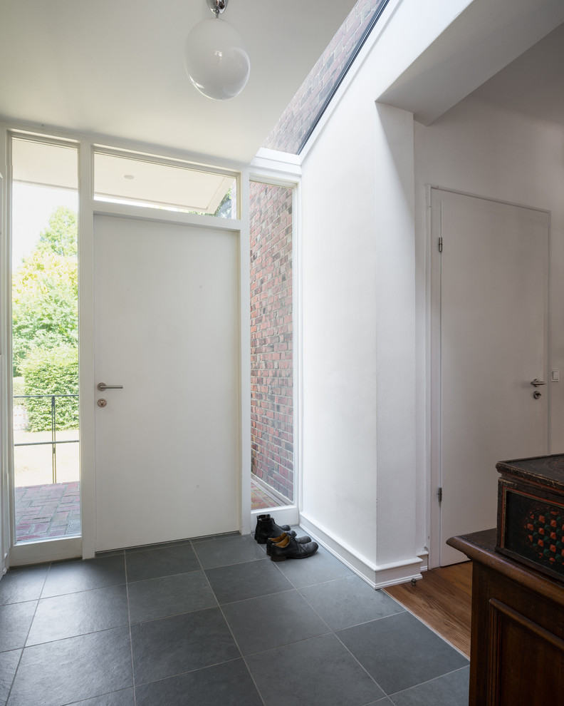 Inspiration for a medium sized contemporary front door in Hamburg with white walls, a single front door, a white front door and slate flooring.