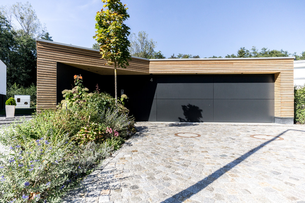Idée de décoration pour une grande entrée design avec un vestiaire, un mur noir, sol en granite, une porte simple, une porte noire et un sol gris.