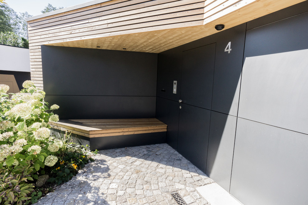 Idéer för ett stort modernt kapprum, med svarta väggar, granitgolv, en enkeldörr, en svart dörr och grått golv