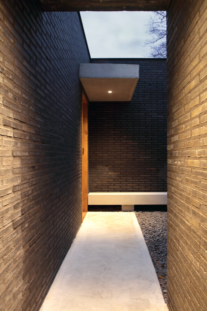 Example of a huge trendy concrete floor and gray floor entryway design in Hanover with brown walls