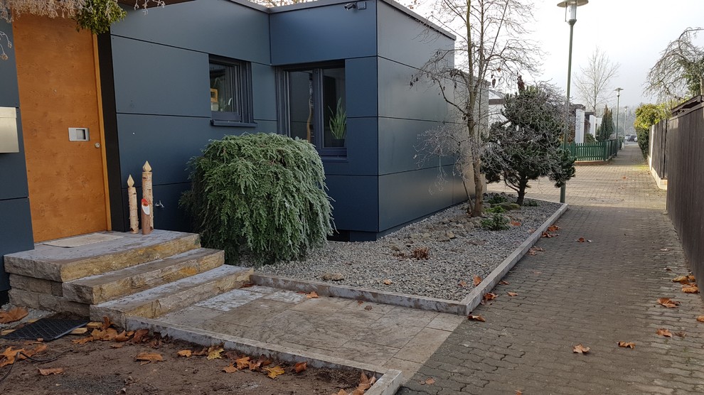 Kleine Moderne Haustür mit blauer Wandfarbe, Backsteinboden, Einzeltür, hellbrauner Holzhaustür und grauem Boden in Frankfurt am Main