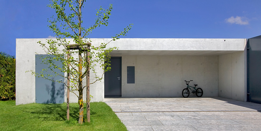 Modern inredning av en mellanstor ingång och ytterdörr, med en enkeldörr, en grå dörr, grå väggar och betonggolv
