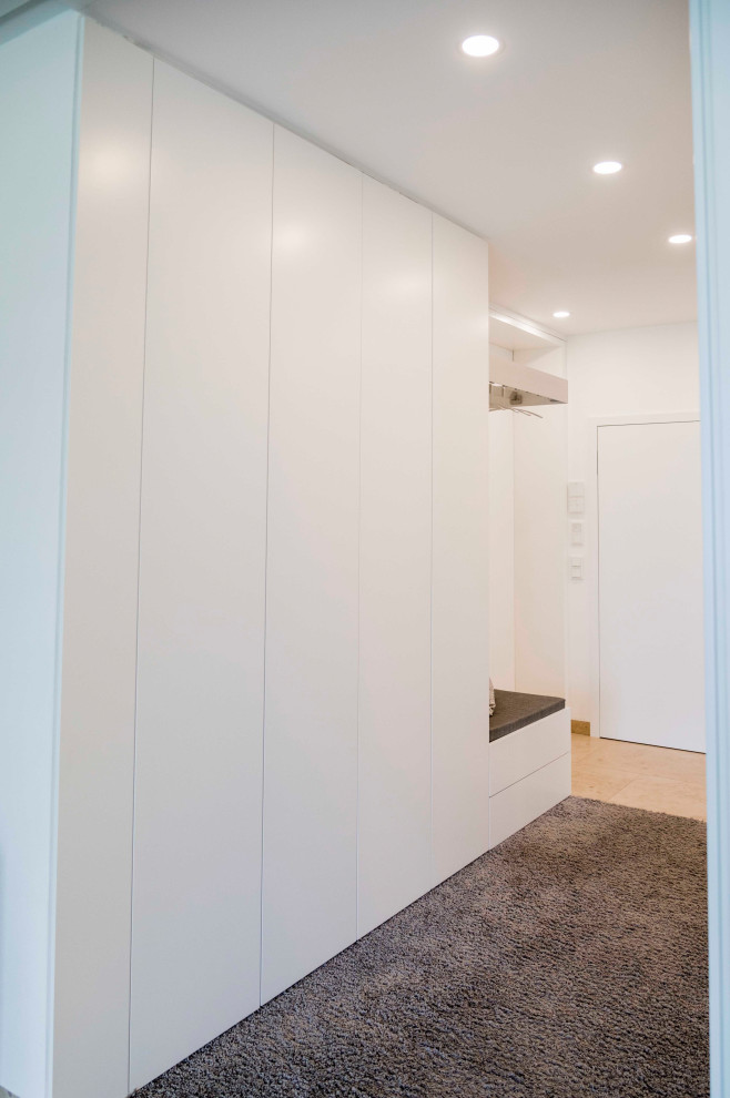 Cette photo montre une entrée tendance de taille moyenne avec un mur blanc, une porte simple et un sol gris.