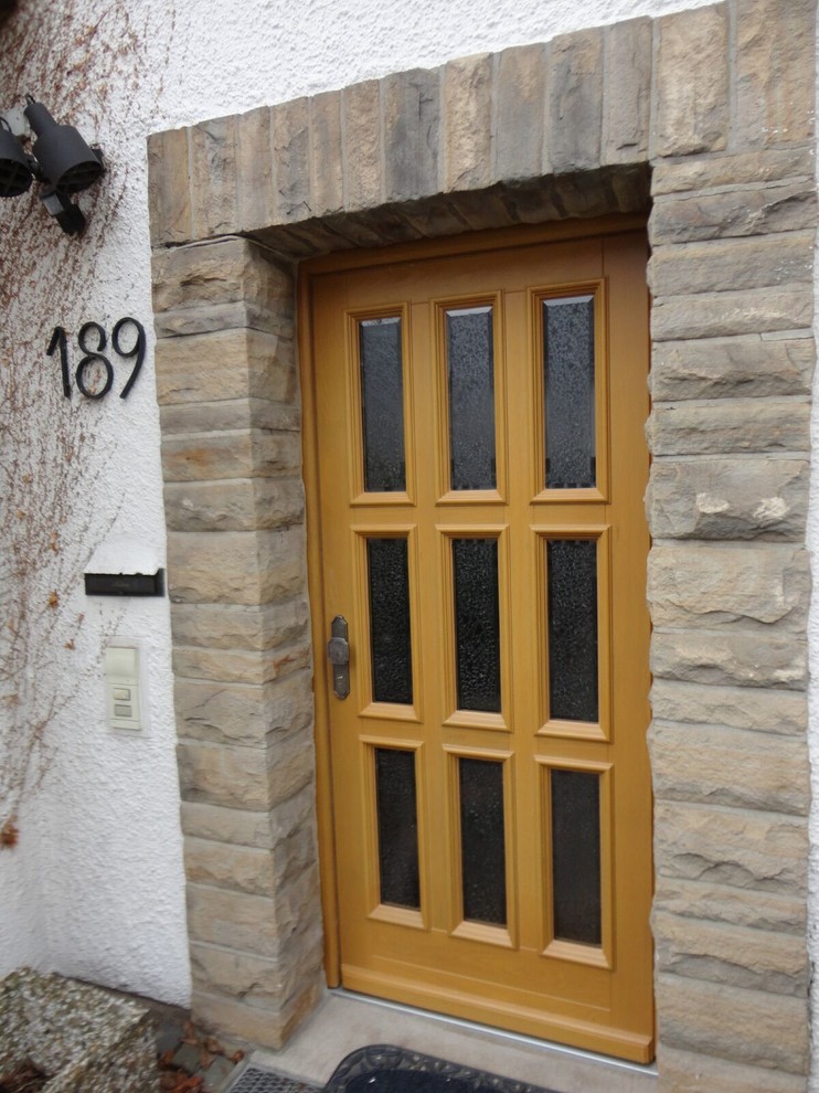 Ispirazione per una porta d'ingresso country di medie dimensioni con una porta singola e una porta in legno chiaro