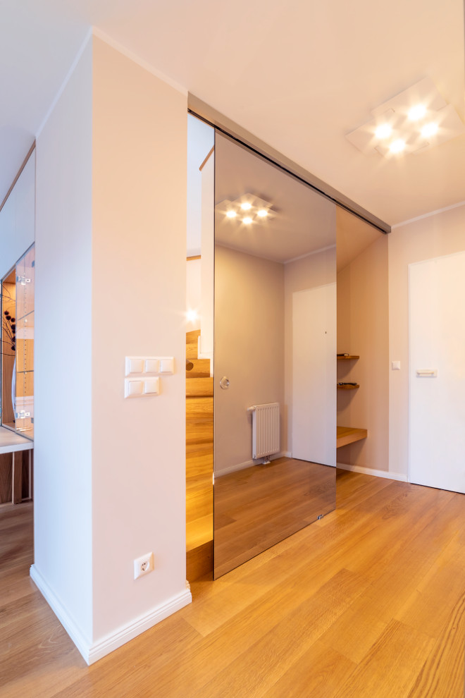 Kleine Moderne Haustür mit beiger Wandfarbe, hellem Holzboden, Einzeltür, weißer Haustür und beigem Boden in Sonstige