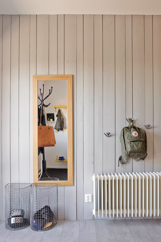 Ejemplo de entrada nórdica grande con paredes grises y suelo de madera clara