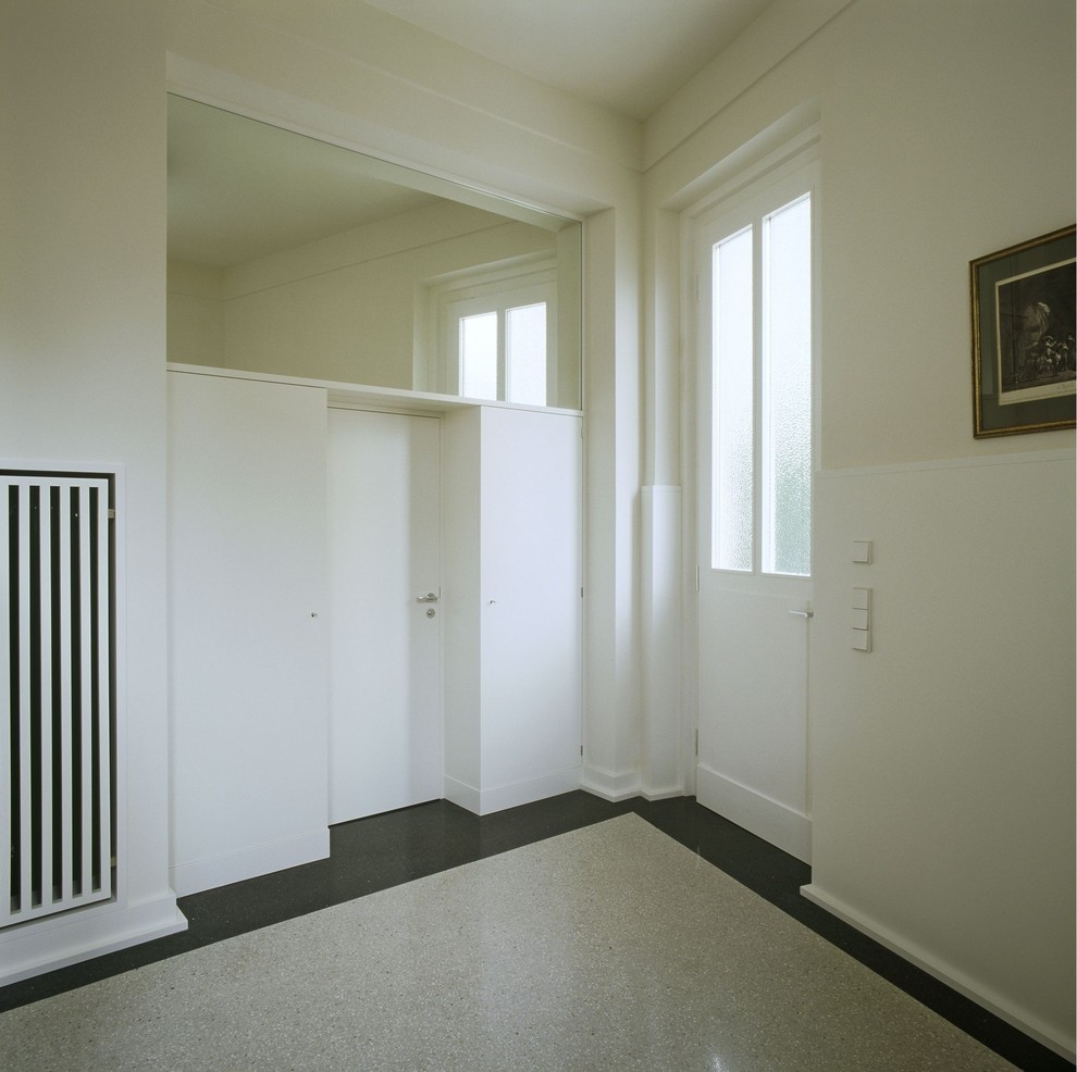Ispirazione per un grande corridoio tradizionale con pareti beige, pavimento alla veneziana, una porta singola e una porta bianca