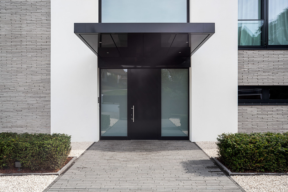Idéer för en modern ingång och ytterdörr, med vita väggar, en enkeldörr och en svart dörr