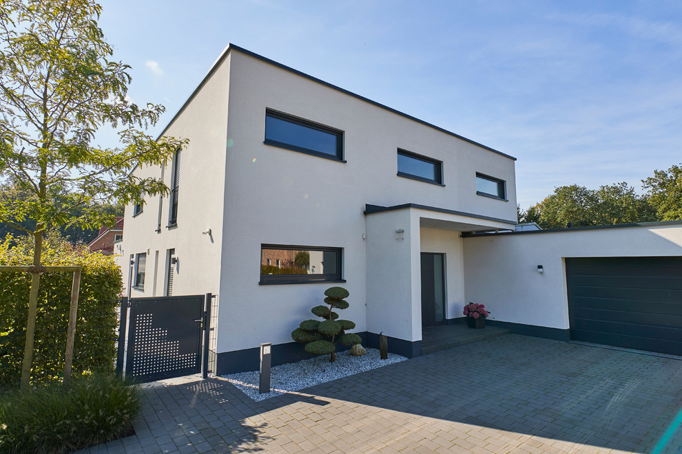 This is an example of a medium sized contemporary front door in Dortmund with white walls, granite flooring, a single front door, a white front door and black floors.