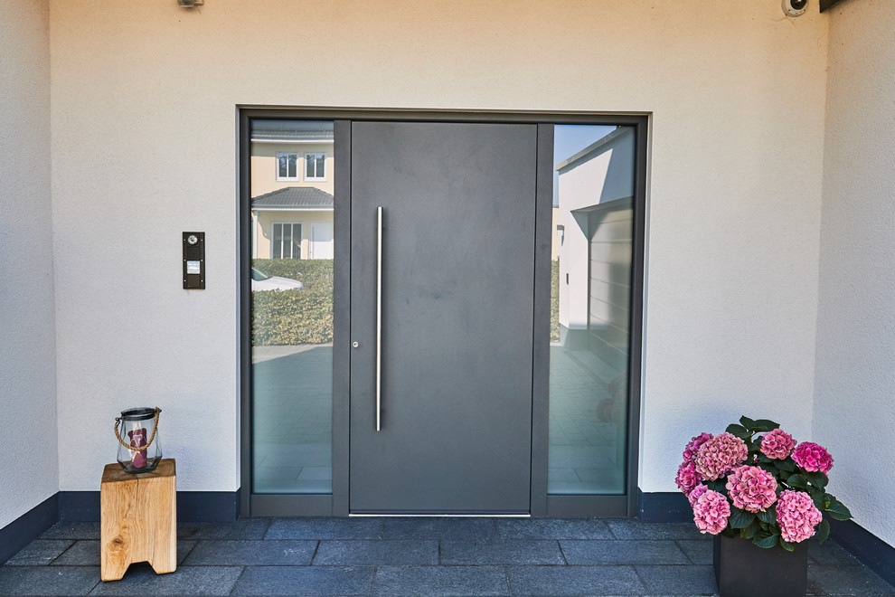 Idées déco pour une porte d'entrée contemporaine de taille moyenne avec un mur blanc, une porte simple, une porte grise, un sol noir et sol en granite.