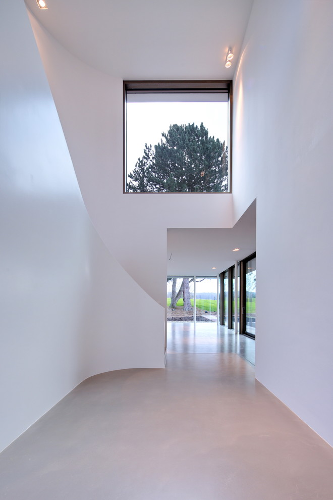 Geräumiges Modernes Foyer mit weißer Wandfarbe, Betonboden und grauem Boden in Bonn