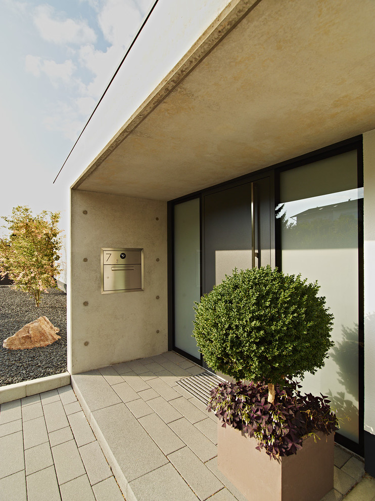 Стильный дизайн: прихожая в современном стиле с одностворчатой входной дверью, серой входной дверью и серыми стенами - последний тренд