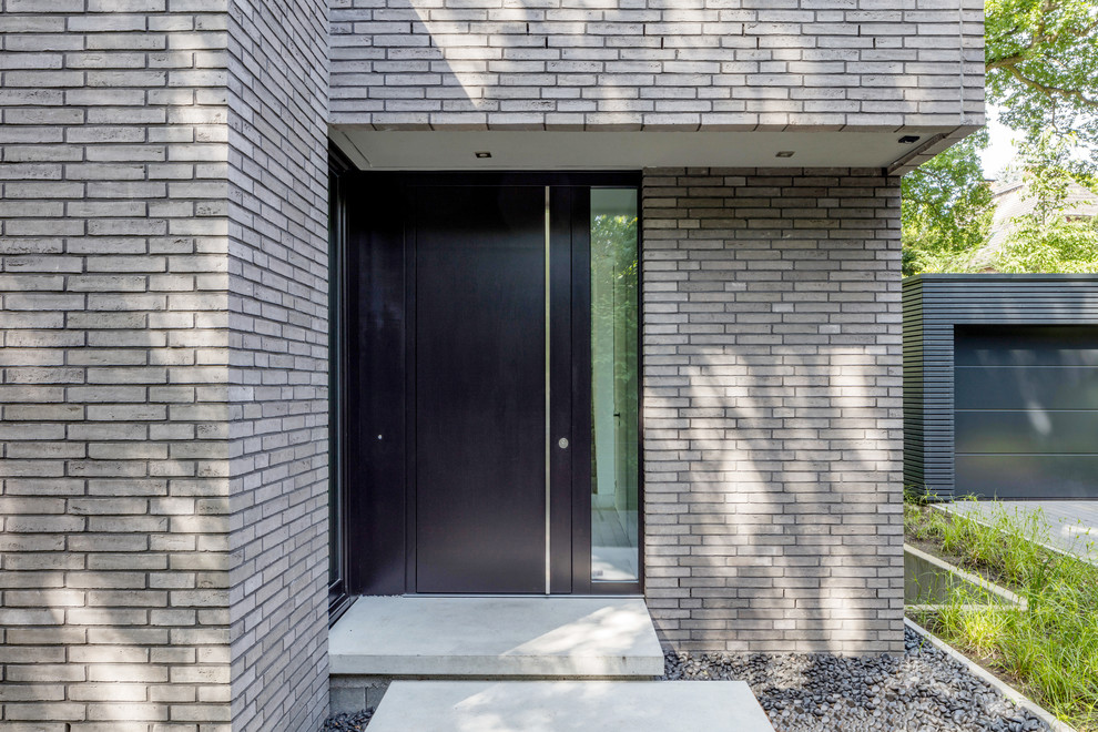 Réalisation d'un hall d'entrée design de taille moyenne avec sol en béton ciré, une porte simple, une porte noire et un sol gris.