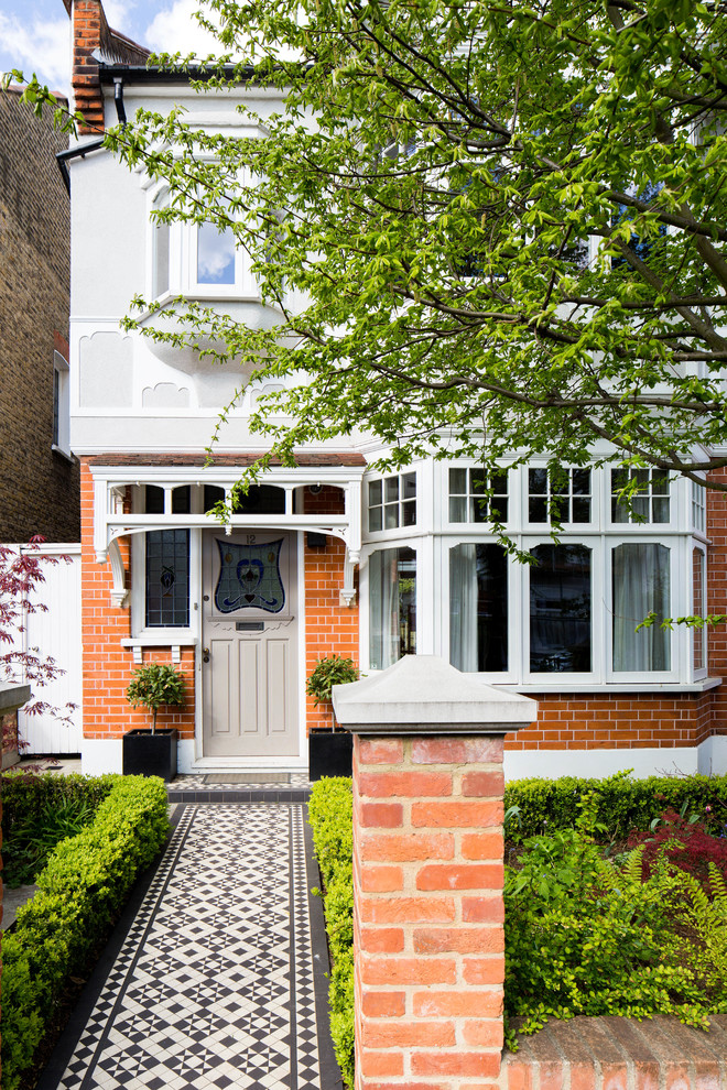 Mid-sized elegant ceramic tile entryway photo in London with red walls and a brown front door