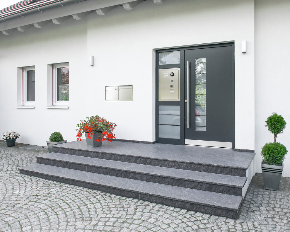 Inredning av en modern ingång och ytterdörr, med vita väggar, granitgolv, en enkeldörr och en grå dörr