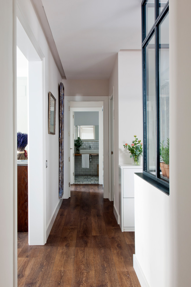 Ejemplo de distribuidor contemporáneo de tamaño medio con paredes blancas, suelo de madera en tonos medios, puerta simple y puerta de madera clara