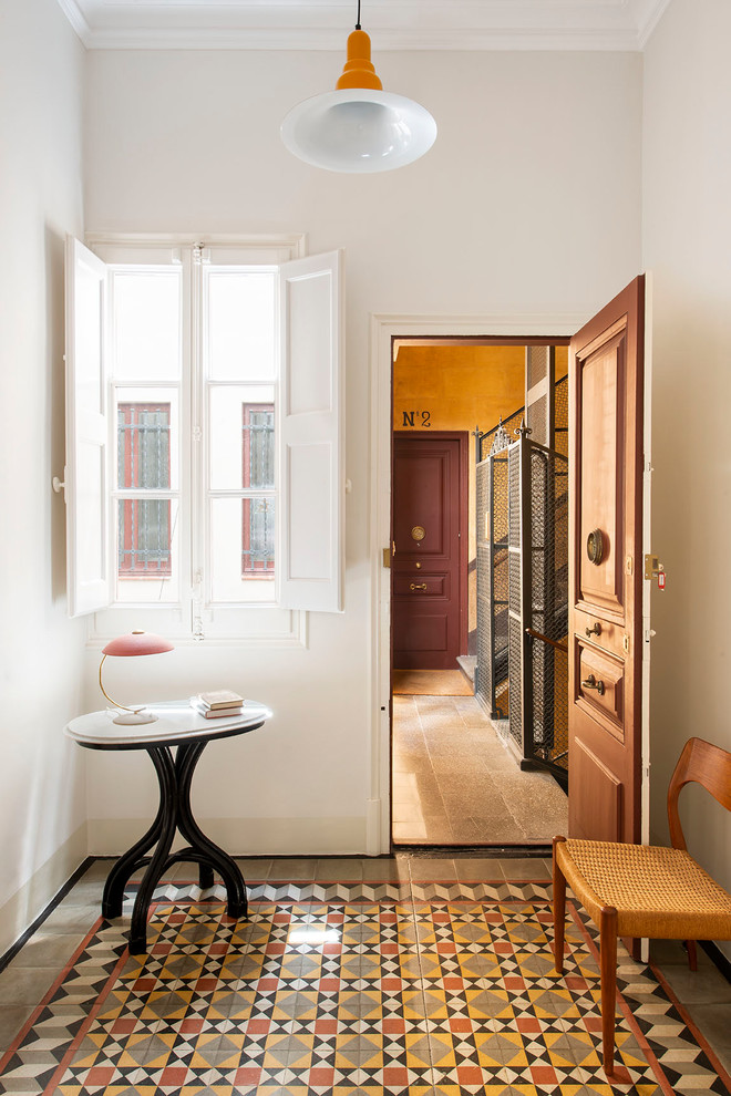 Modelo de puerta principal clásica renovada con paredes blancas, puerta simple, puerta de madera en tonos medios y suelo multicolor
