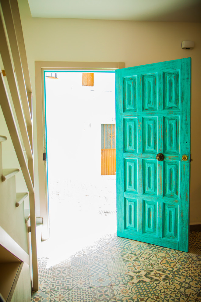 Пример оригинального дизайна: маленькая входная дверь в средиземноморском стиле с бежевыми стенами, полом из керамической плитки, одностворчатой входной дверью, синей входной дверью и разноцветным полом для на участке и в саду