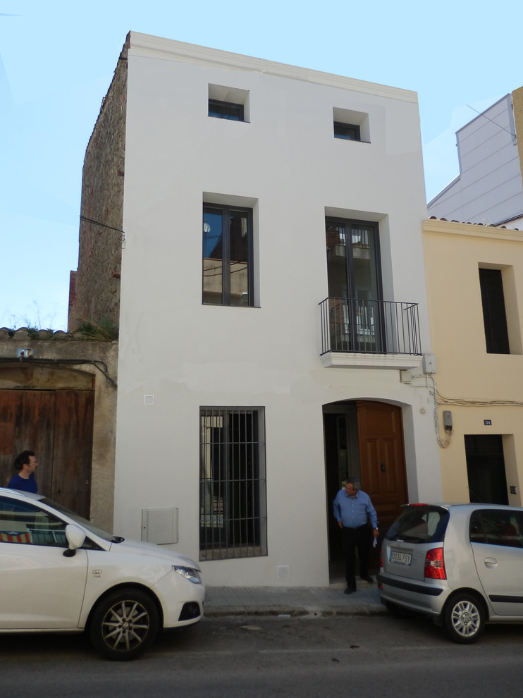バルセロナにあるお手頃価格の小さな地中海スタイルのおしゃれな玄関 (白い壁、茶色いドア) の写真