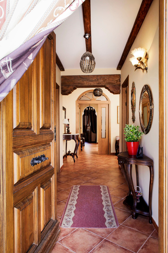 Foto de puerta principal de estilo de casa de campo de tamaño medio con paredes blancas, suelo de baldosas de terracota, puerta simple y puerta de madera oscura