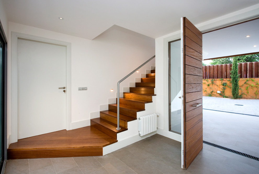Idée de décoration pour un petit hall d'entrée design avec un mur blanc, un sol en carrelage de céramique, une porte simple et une porte en bois foncé.