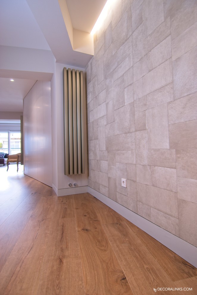 Diseño de entrada contemporánea con paredes beige y suelo de madera clara