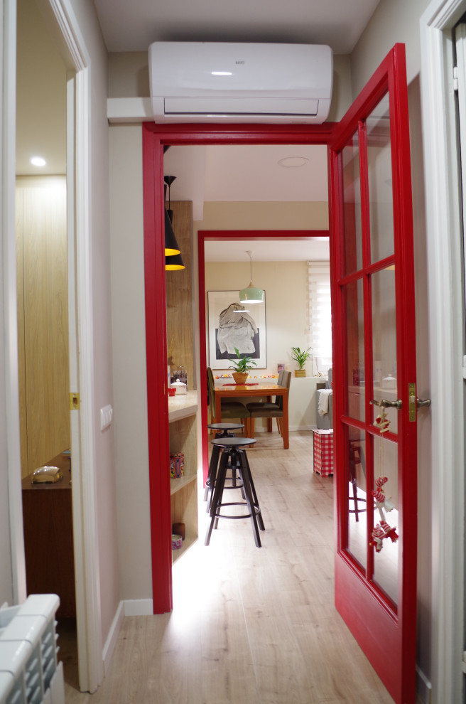 Imagen de entrada vintage con suelo laminado, puerta roja y suelo marrón